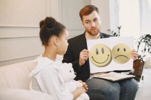 Thérapeute montrant des cartes émotions à une petite fille lors d'une séance